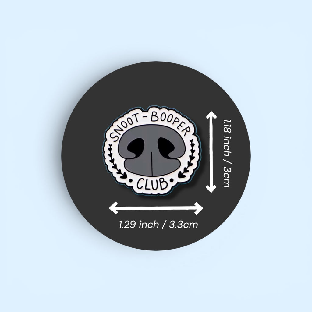 Pin with 'Snoot Booper Club' design and size measurements on a black background