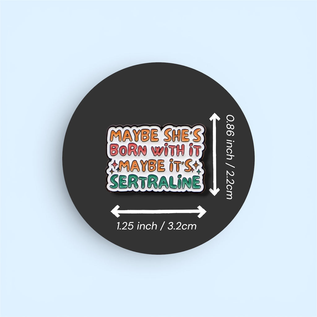 Enamel pin with text 'MAYBE SHE'S BORN WITH IT MAYBE IT'S SERTRALINE' on a black background