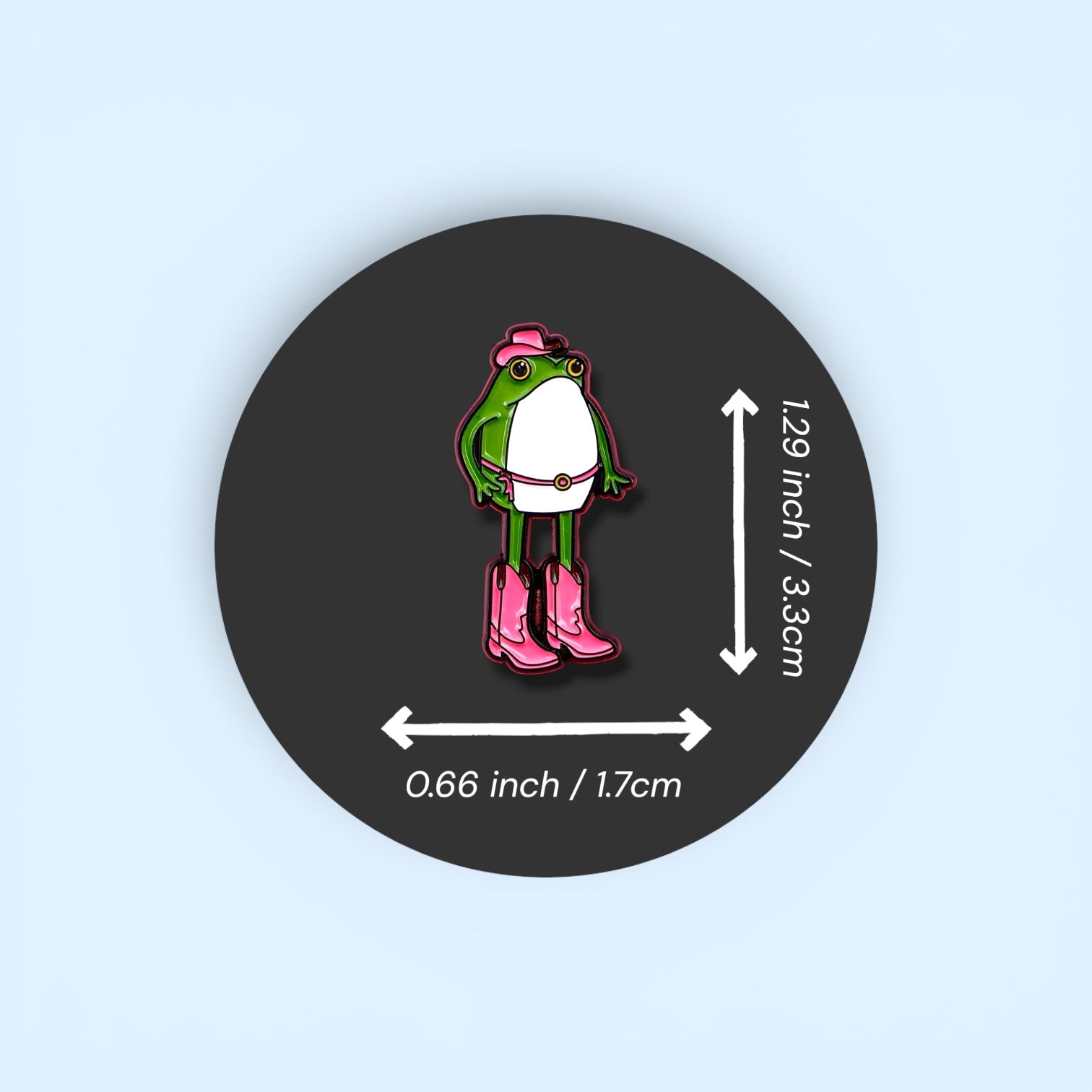 Pin with a frog character wearing pink boots and a hat, shown with measurements on a dark background.