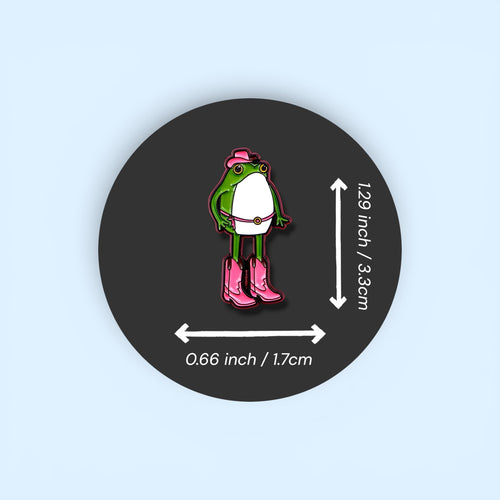 Pin with a frog character wearing pink boots and a hat, shown with measurements on a dark background.