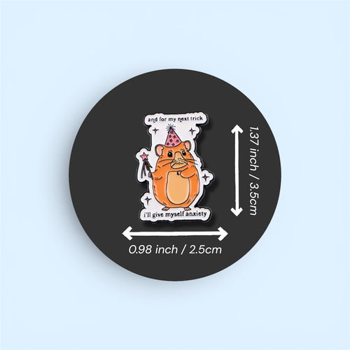 Pin with a cartoon hamster wearing a party hat and wand with text 'and for my next trick I'll give myself anxiety', displayed on a black background with measurements.